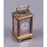 A brass travel alarm clock with polychrome decorated plaques, 20th century.
H.: 5,5 cm.