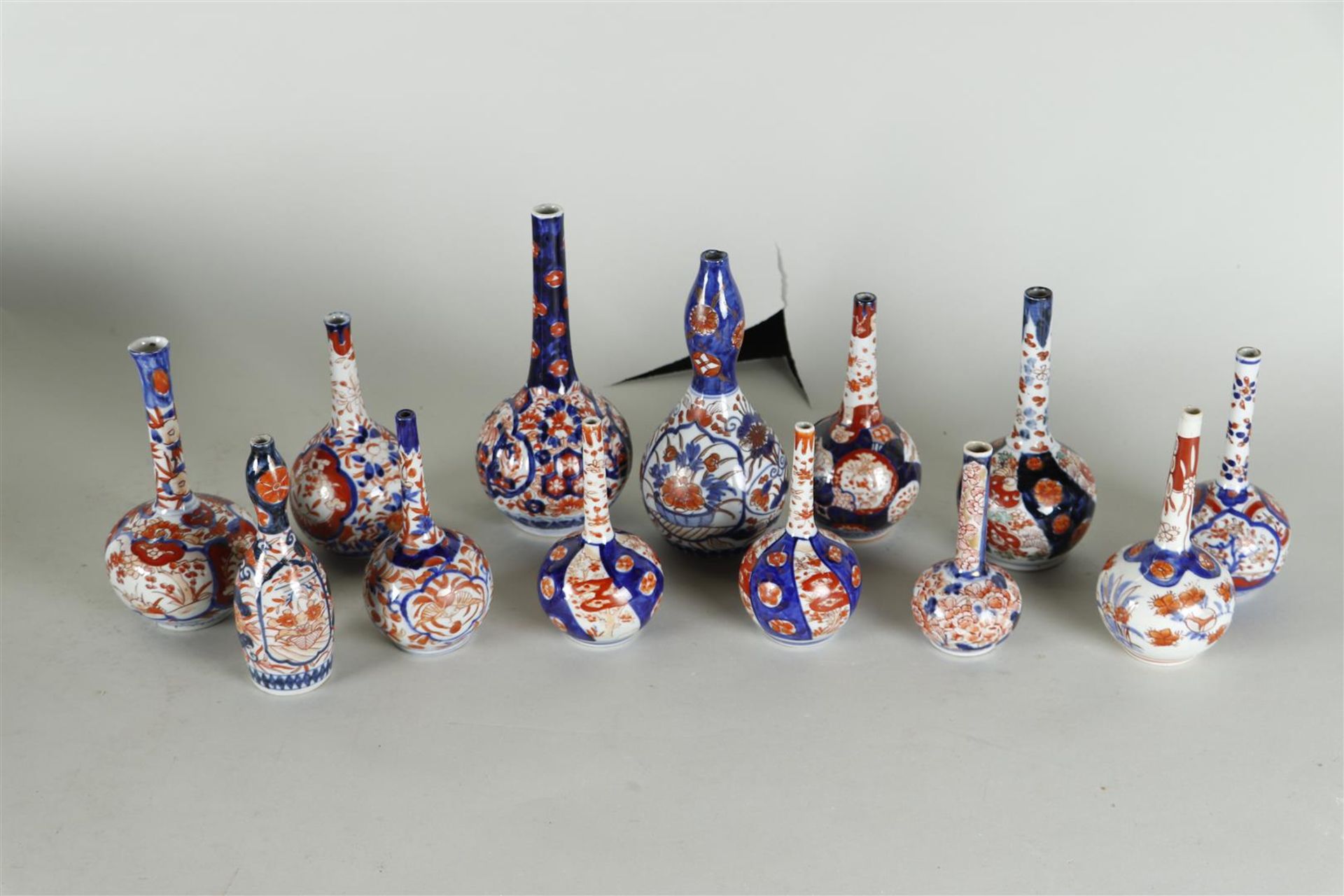 A lot of thirteen Imari pipe vases. Japan, 19th century.
H. 13 - 19 cm.