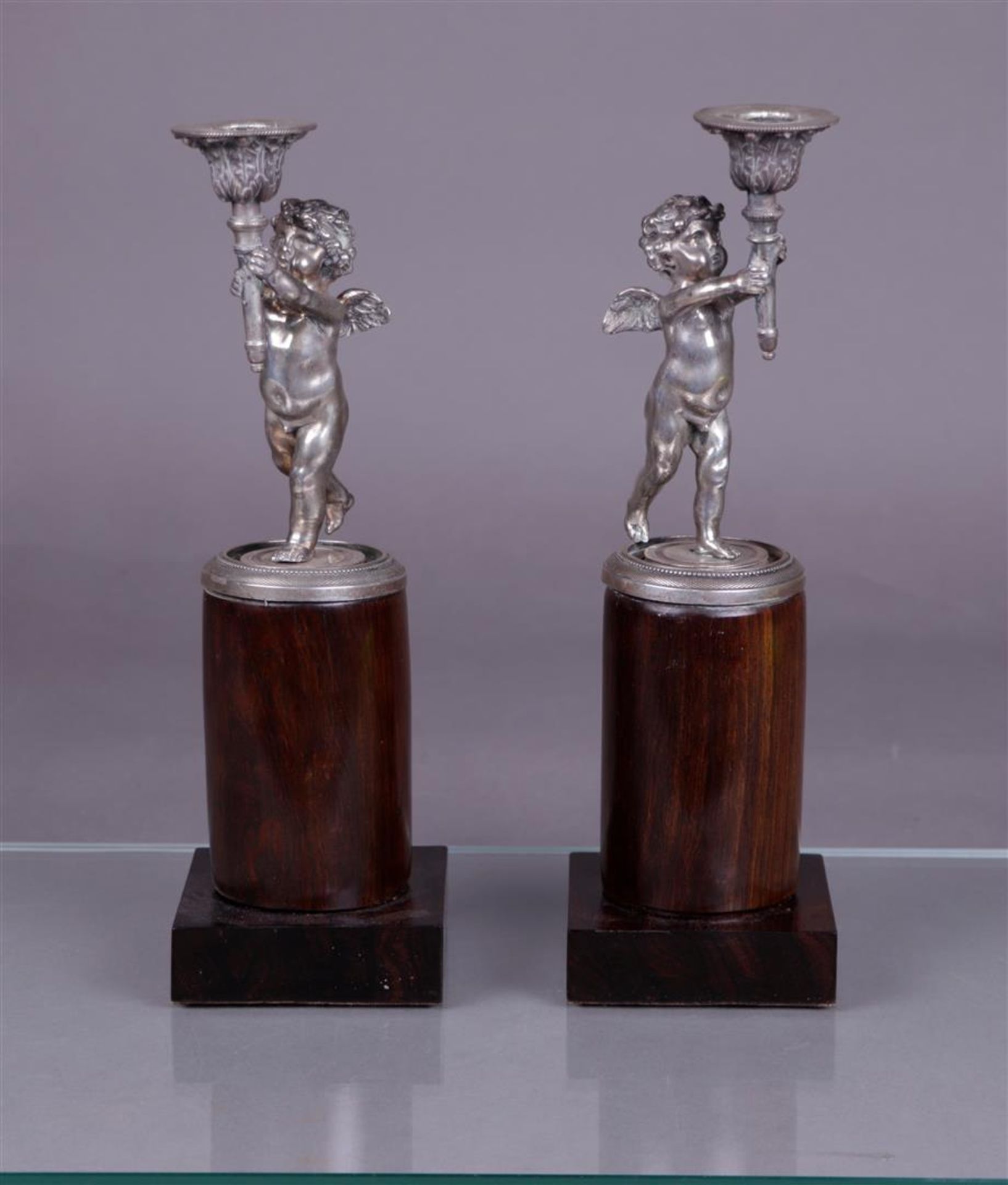 A pair of silver candlesticks in the shape of torch-bearing putti (BWG), mounted on a polished woode - Image 2 of 4