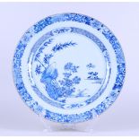 A porcelain dish with rich floral decoration near a rock with butterfly, outer edge with floral deco