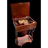An early 19th century mahogany Biedermeier sewing table with contents divided into compartments unde