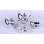 A silver four-piece tea set; Teapot, coffee pot, milk jug and sugar bowl, the teapot with brown wood