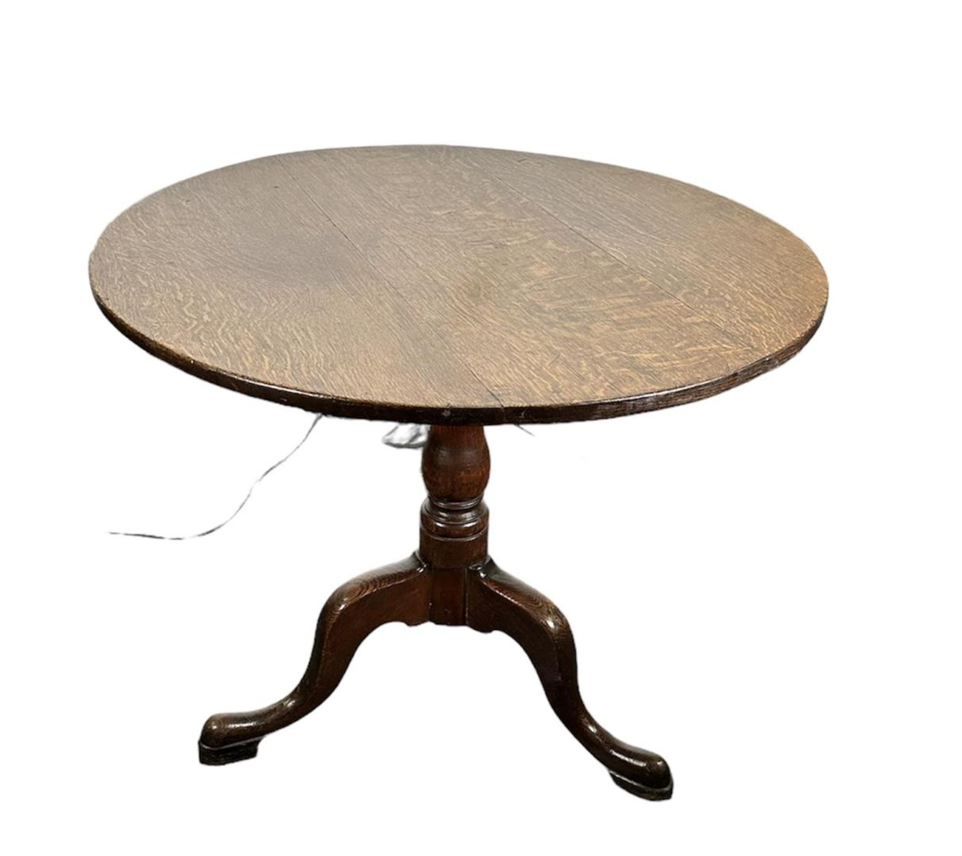 An oak 'occasional' table with a round top on three legs. England, first half of the 19th century.