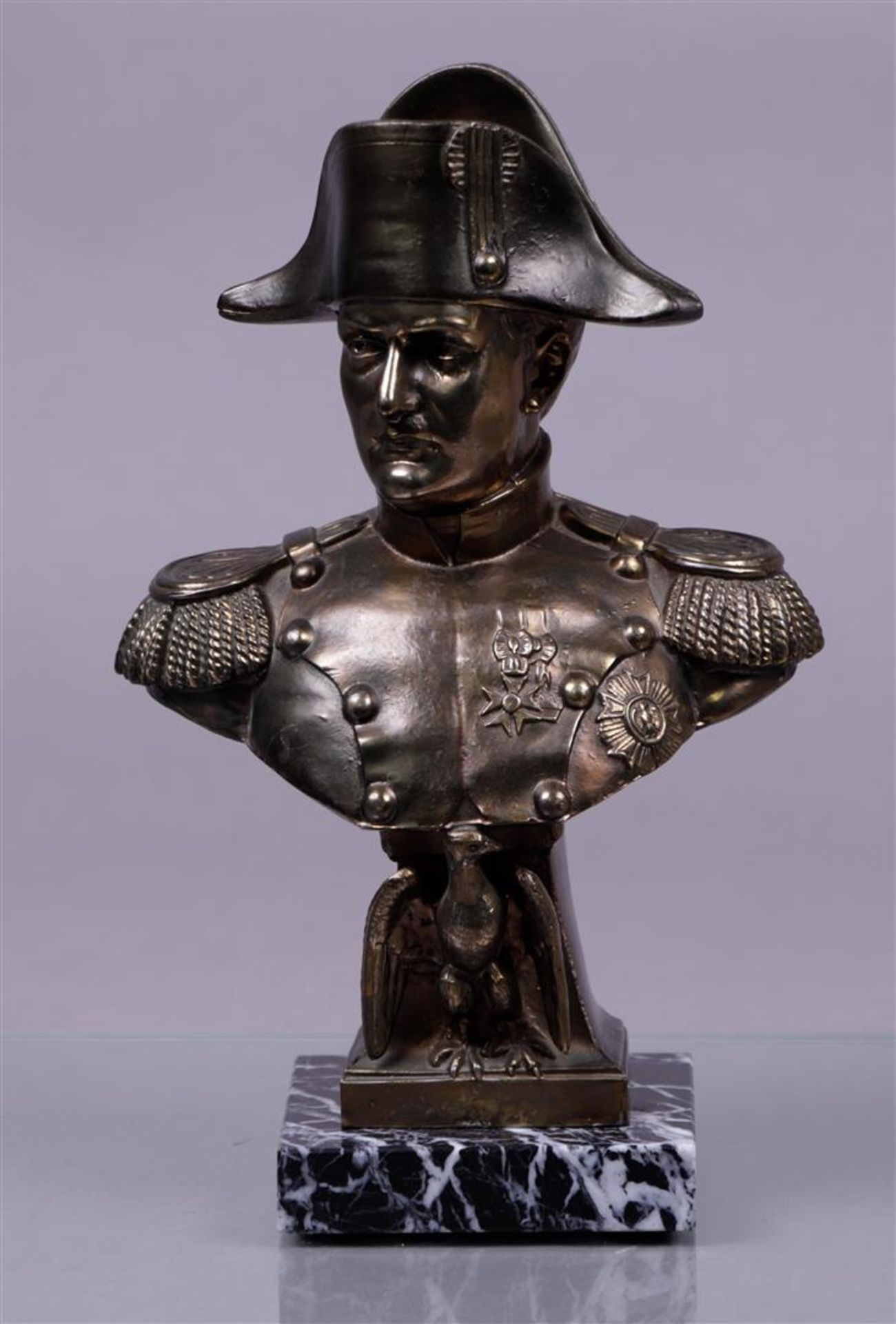 A cast bronze bust of Napoleon on a marble base.
H.:m 26,5 cm.