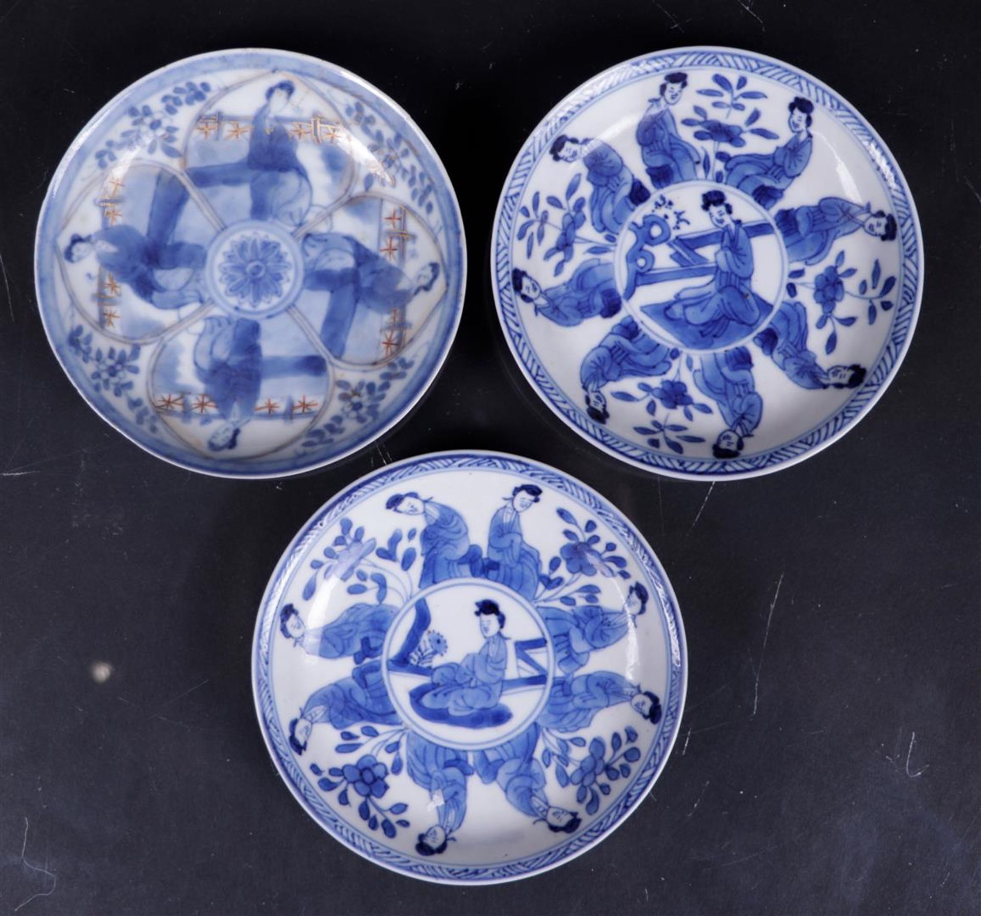 Three porcelain saucers with a decor of sitting long frames, marked with a shell in a double circle.