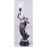A cast metal statue of a woman holding a torch. (lamp). France, ca. 1900.
H.: 70 cm.