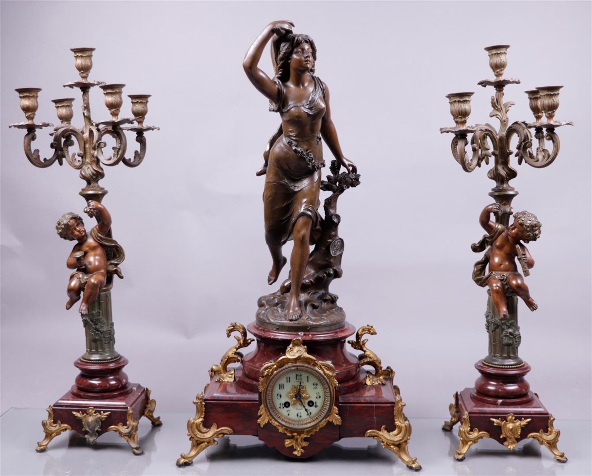 A capital garniture de chŽminŽe consisting of a mantel clock with a clock statue after Bruchon 'Temp