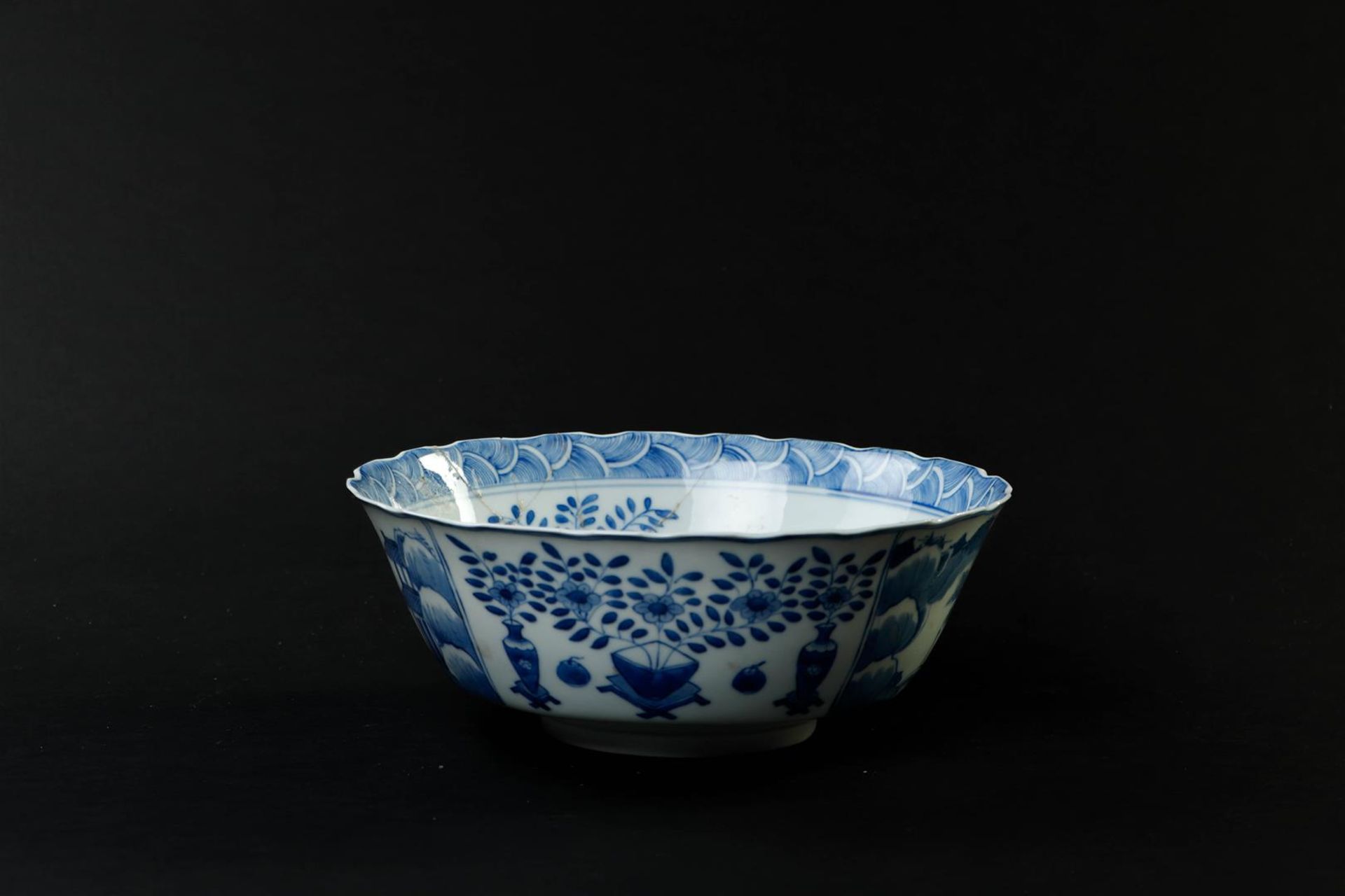 A large porcelain bowl decorated with landscapes and antiques, marked Kangxi. (glued).