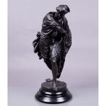 A darkly patinated metal statue on a wooden base of a Neapolitan fisherman casting his net. 19th cen
