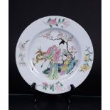 A porcelain Famille rose plate decorated with two figures and a ruby red ground on the back. China, 