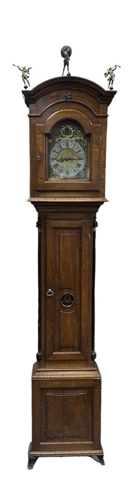 A grandfather clock with atlas and fama images. Simple timepiece.
H.: 278 cm.