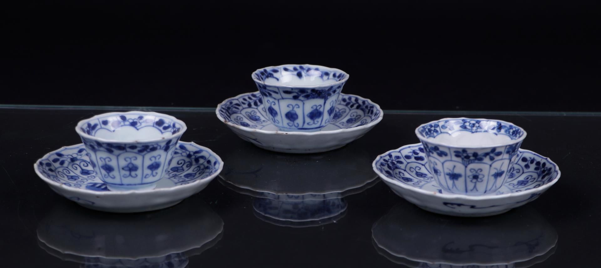 Three blue/white cups and saucers, 2 figures at the table with more decor. China, Qianlong.
Diam. 11