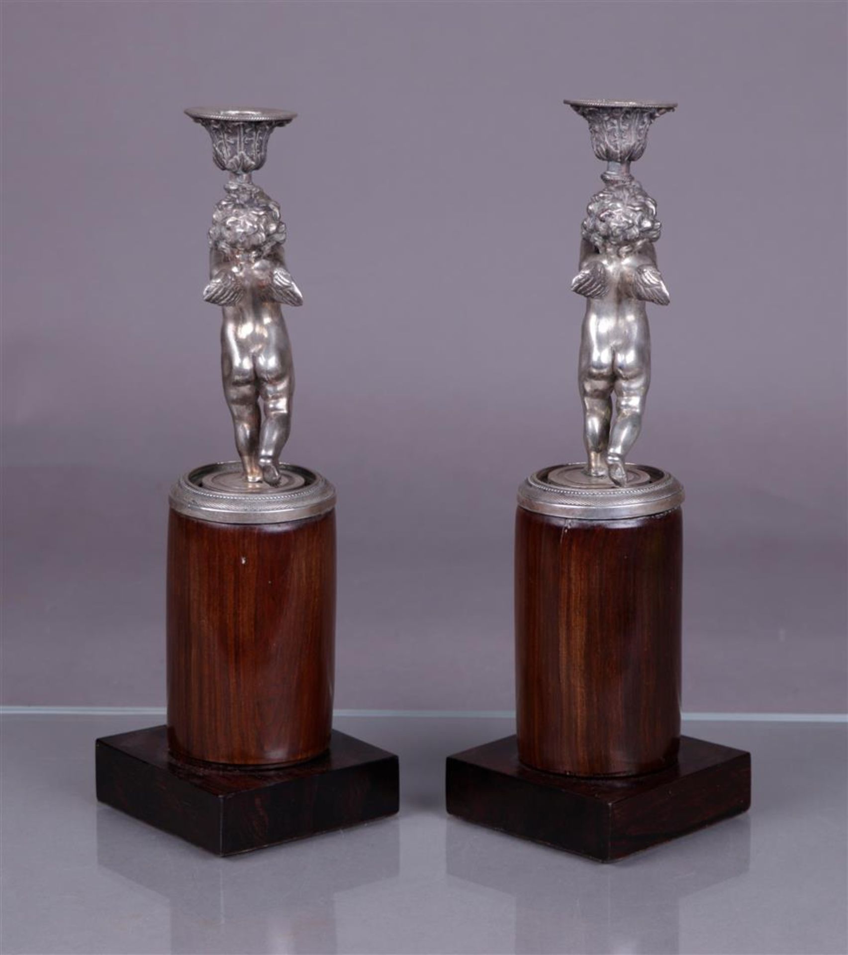 A pair of silver candlesticks in the shape of torch-bearing putti (BWG), mounted on a polished woode - Image 3 of 4