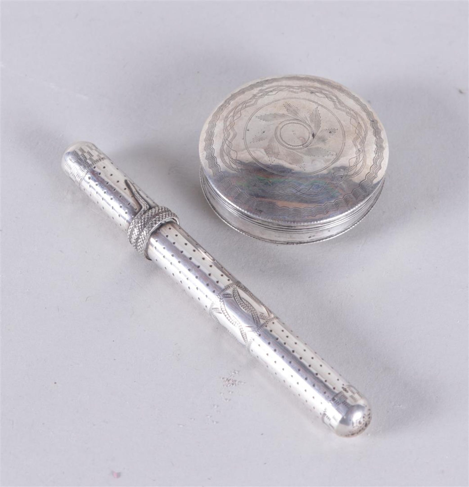 A lot of silver consisting of a pill box marked pk and a needle case marked sword. 41 grams.