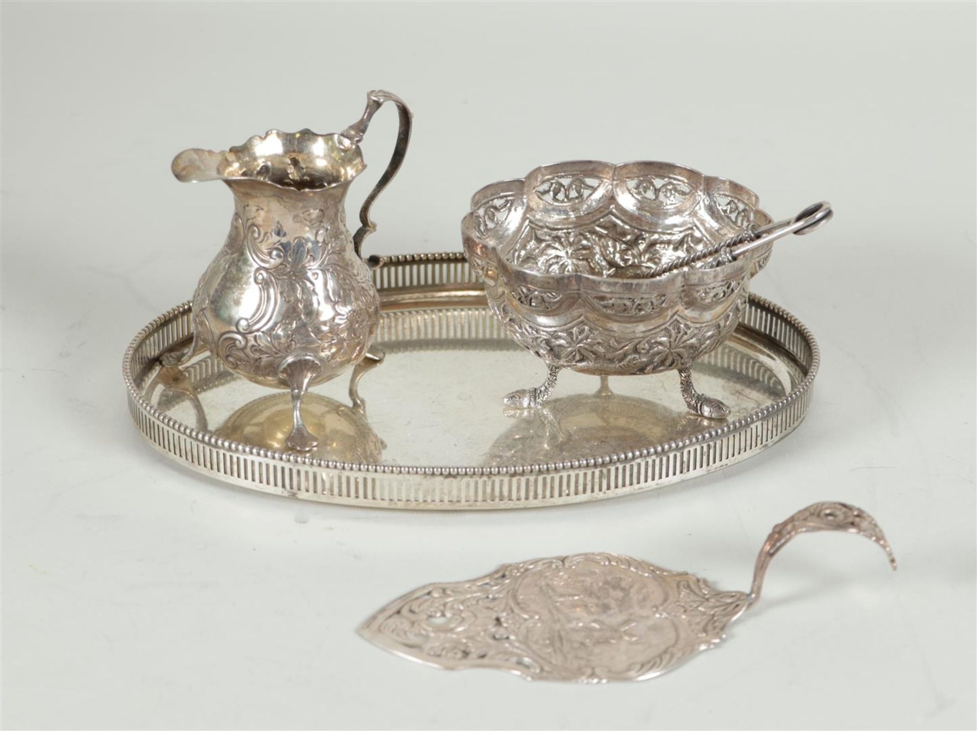 A silver cream set with lump tongs on a tray, plus a cake scoop.