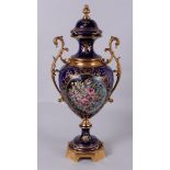 A Sevres-style lidded vase with brass frame.
H. 62 cm.