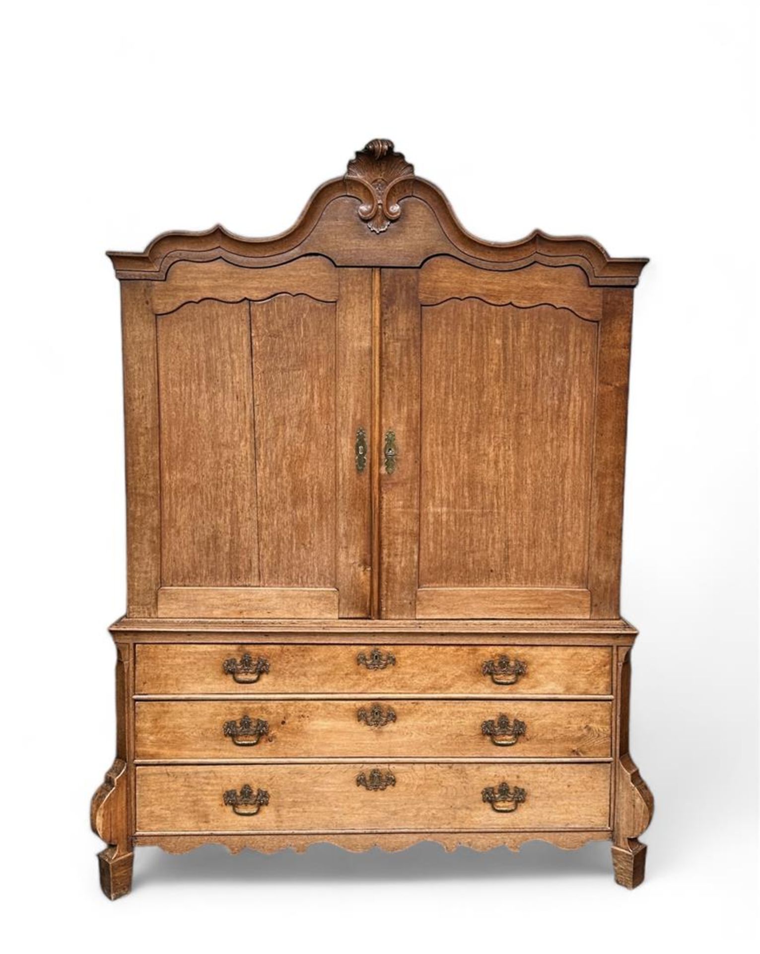 An oak cabinet with carved crested base cabinet with drawers, Holland, 18th century.
H.: 240 cm.