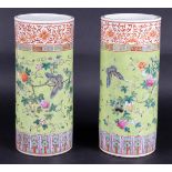 A set of two porcelain famile rose cylinder vases decorated with flowers and butterflies, partly wit
