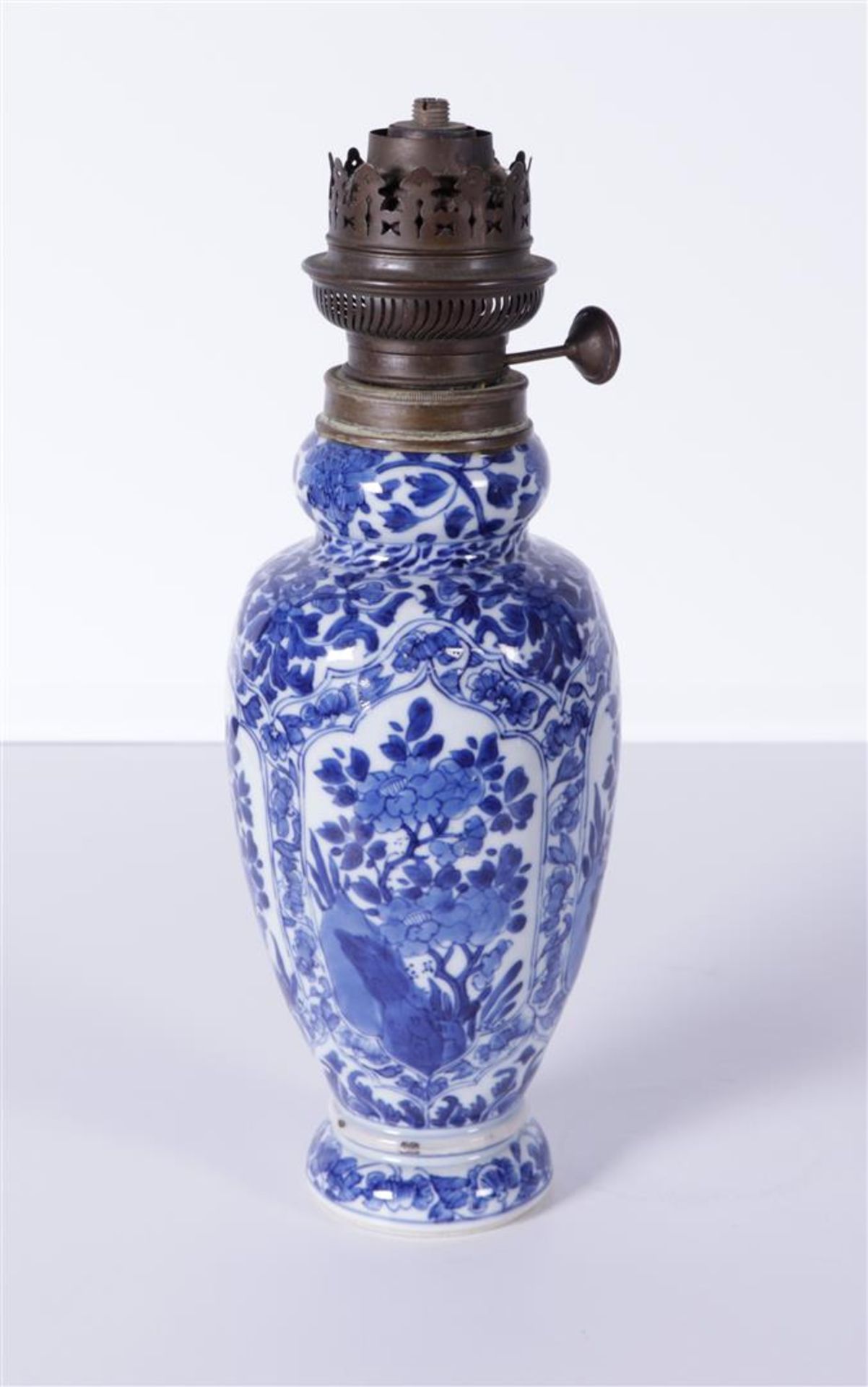 A porcelain baluster vase with floral decor. China, Kangxi. converted into an oil lamp.
H. 33 cm.