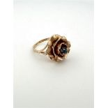 14kt rose gold ring in the shape of a rose set with sapphire.
The sapphire is an old European cut. T