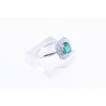 9kt white gold entourage ring set with one radiant cut syn. emerald and 14 brilliant cut diamonds of