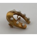 14kt yellow gold horseshoe brooch set with imitation pearls.
The brooch features 7 imitation pearls,