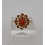 14kt yellow gold rosette ring set with red coral.
The ring is set with 1 central oval cabochon cut r