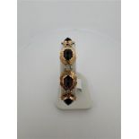 14kt yellow gold bracelet with garnet.
The bracelet is set with 9 imitation garnet gemstones. The st