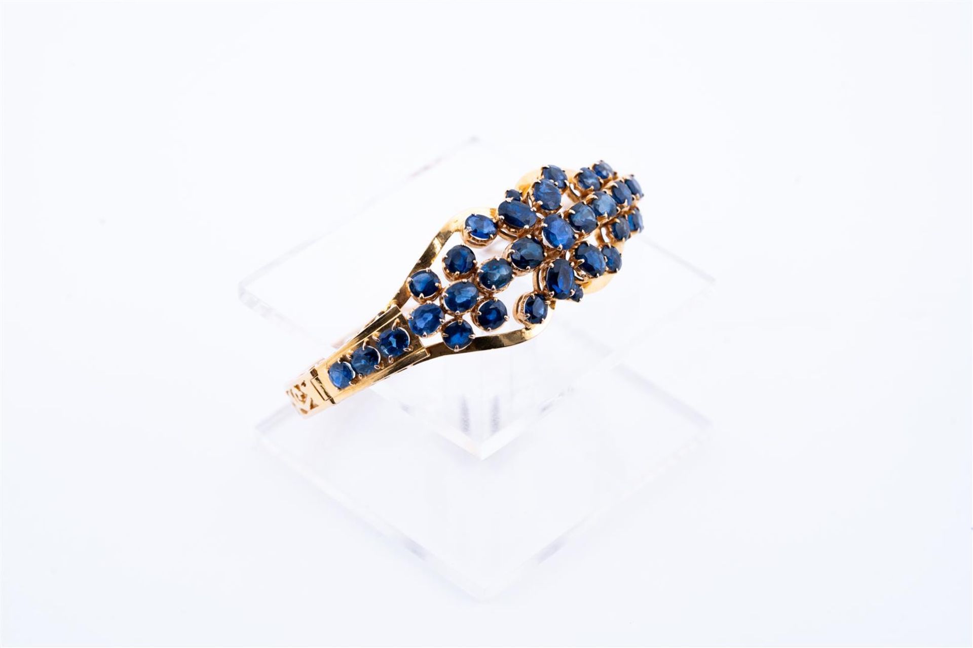 18kt Yellow gold cluster bracelet set with 33 blue sapphires. The bracelet has a beautiful openwork 