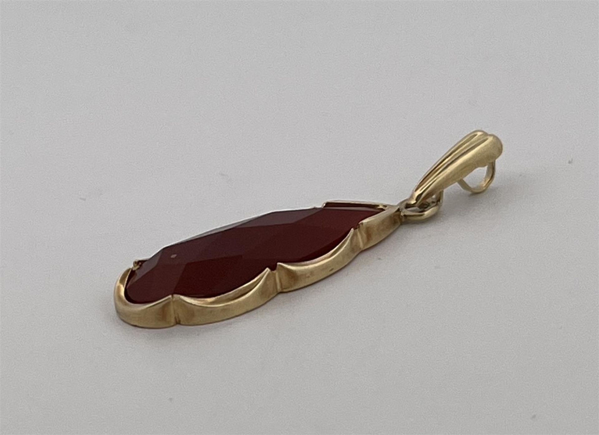 14kt yellow gold drop-shaped pendant set with carnelian.
The pendant is set with a drop-shaped facet - Bild 2 aus 3