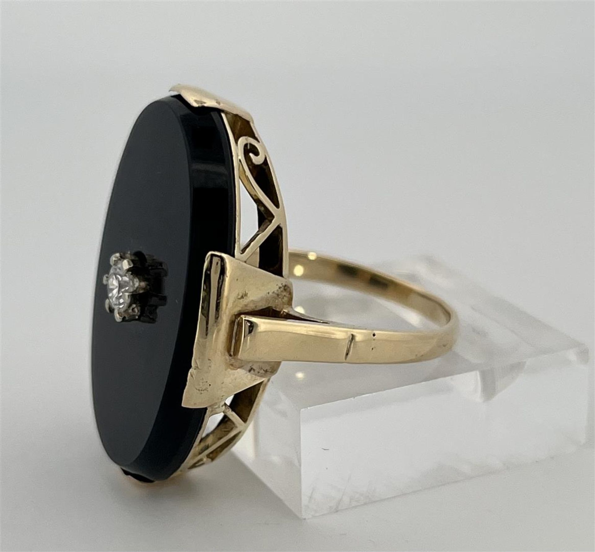 14kt Yellow gold ring set with onyx and diamonds.
The ring has a high openwork edge with a set onyx 