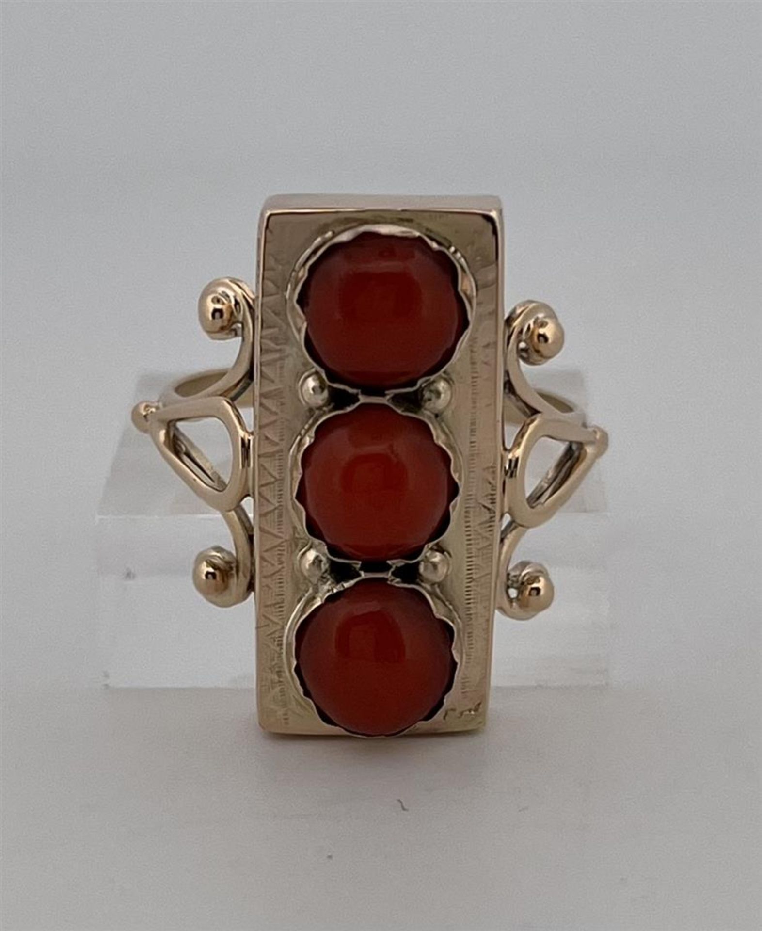 14kt yellow gold 3-stone ring set with red coral.
The ring is set with 3 round cabochon cut red cora