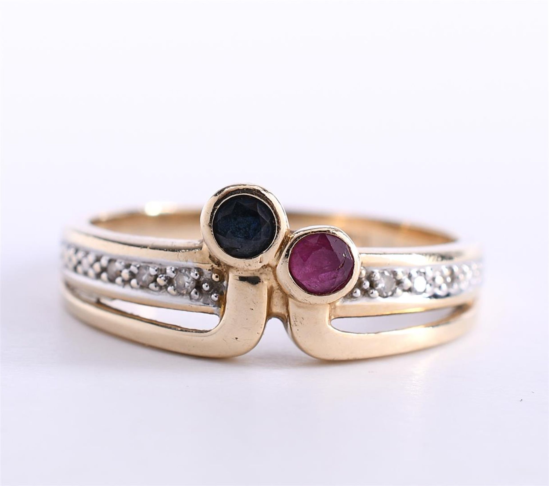 14 kt yellow gold fantasy ring set with a brilliant cut ruby and a brilliant cut blue sapphire of ap