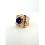 18kt yellow gold statement college ring set with Lapis Lazuli. 
The lapis lazuli is round and caboch