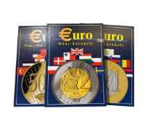A collection of three Euro collection coins in folders.
