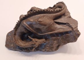 A SIGNED BRONZE DRAGON ON A ROCK SIGNED D DUDLEY 9" WIDE