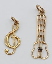 2 GOLD MUSICAL CHARMS/PENDANTS OF GUITAR WITH A SAPPHIRE AND TREBLE CLEF