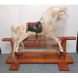 A 20th CENTURY DAPPLE GREY PAINTED ROCKING HORSE WITH LEATHERETTE TACK ON A TREADLE BASE LENGTH 45"