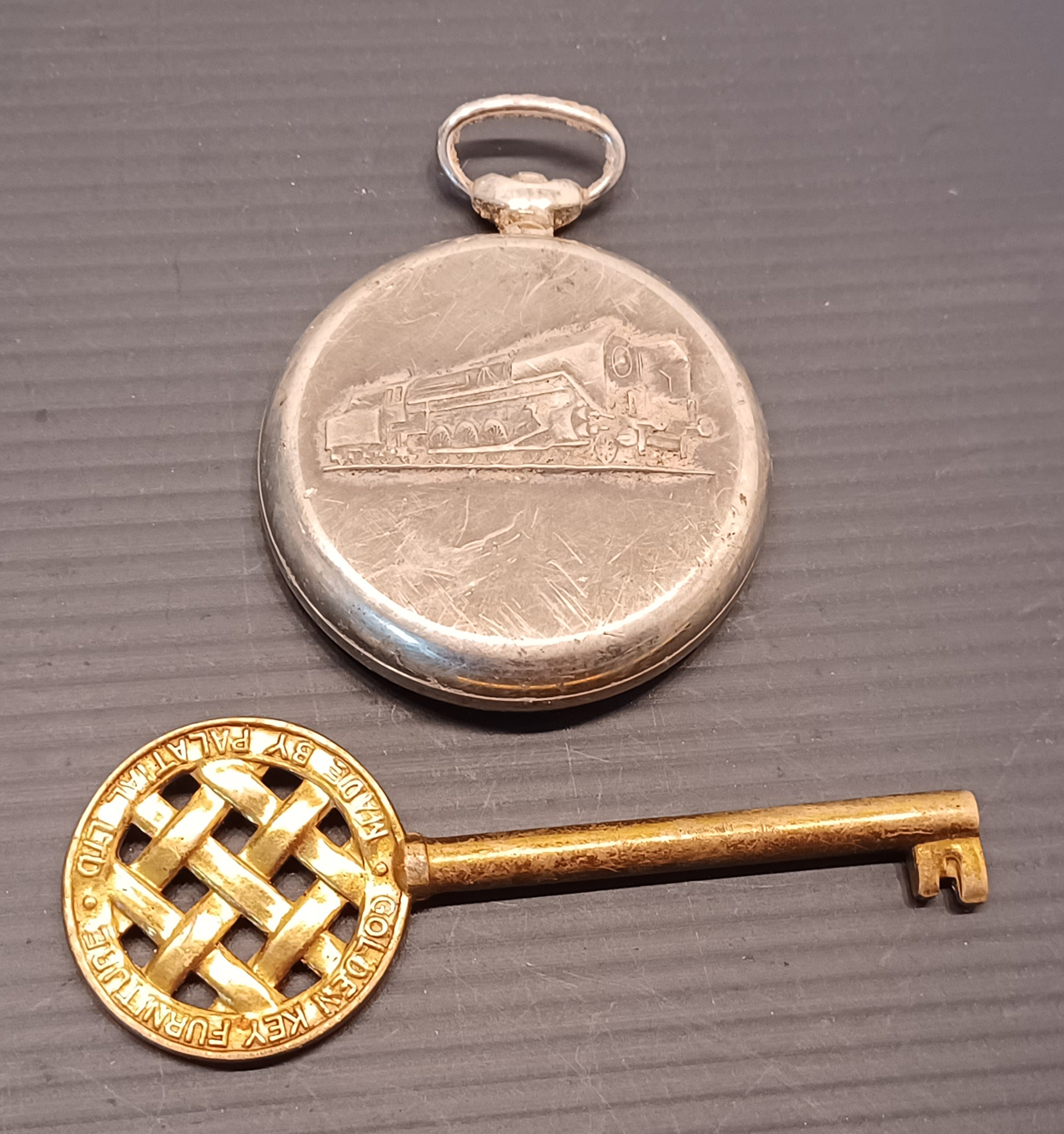 A SEKONDA POCKET WATCH WITH GOLDEN KEY