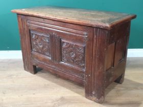 An early 17th Century oak Coffer with later lid above carved two panel front and raised upon heavy