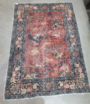 A Persian Rug with border design of trees, deer, etc, the central ground depicting hunters on