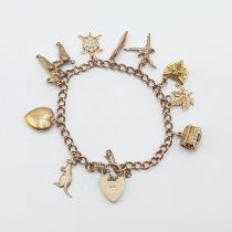 A 9ct gold fine curb link Bracelet on padlock fastener suspending mostly 9ct gold charms, approx