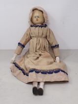 An antique folk art Peg Doll with painted facial features, hands and legs in traditional rustic