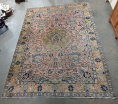 A Persian Carpet with designs of flowers in colours to the border, the central ground decor stylised