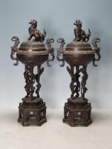 A pair of Chinese bronze Temple Urns and Covers with Kylin finials, the urns on three serpent