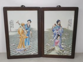 A pair of Chinese Porcelain Panels depicting Figures in Landscapes and text, mounted in wooden