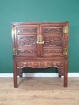 A Chinese hardwood Cabinet on stand, the pair of cupboard doors carved vases and flowering branches,