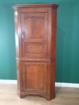 An antique oak double Corner Cupboard, the upper door with cupid's bow and chequered strung panelled