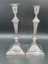 A pair of Victorian silver Pillar Candlesticks with fluted tapering columns on square bases,
