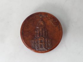 A 19th Century French pressed wood circular Tobacco Box with relief design of a cathedral surrounded